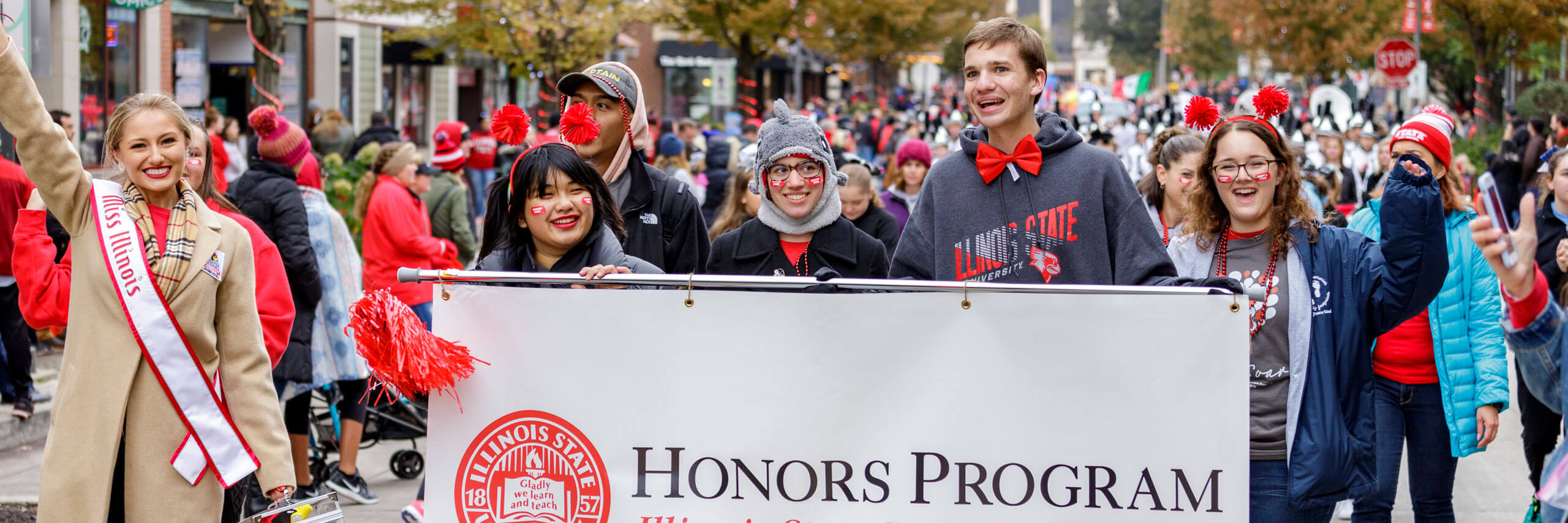 Students hold the Honors Program Banner in the 2019 Homecoming Parade.